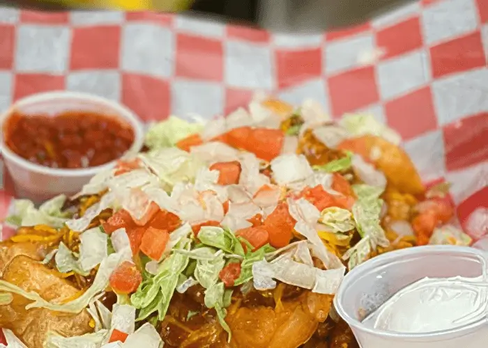 Picture of a Frybread taco, salsa and sour cream.