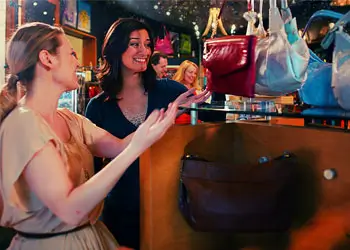 A picture of two women shopping for purses.