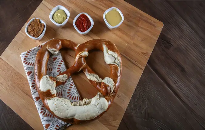 A giant pretzel with four different dipping sauces.