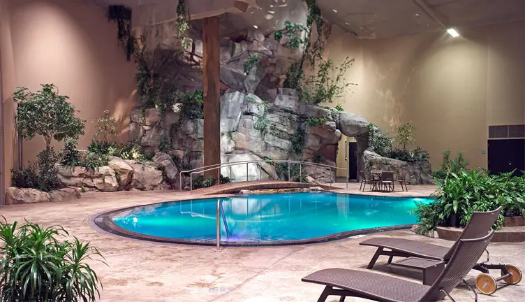 An image of the pool area highlighting the lounges and the waterfall.