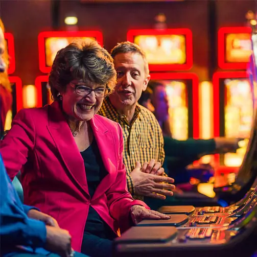 An image of happy people playing slots machines.